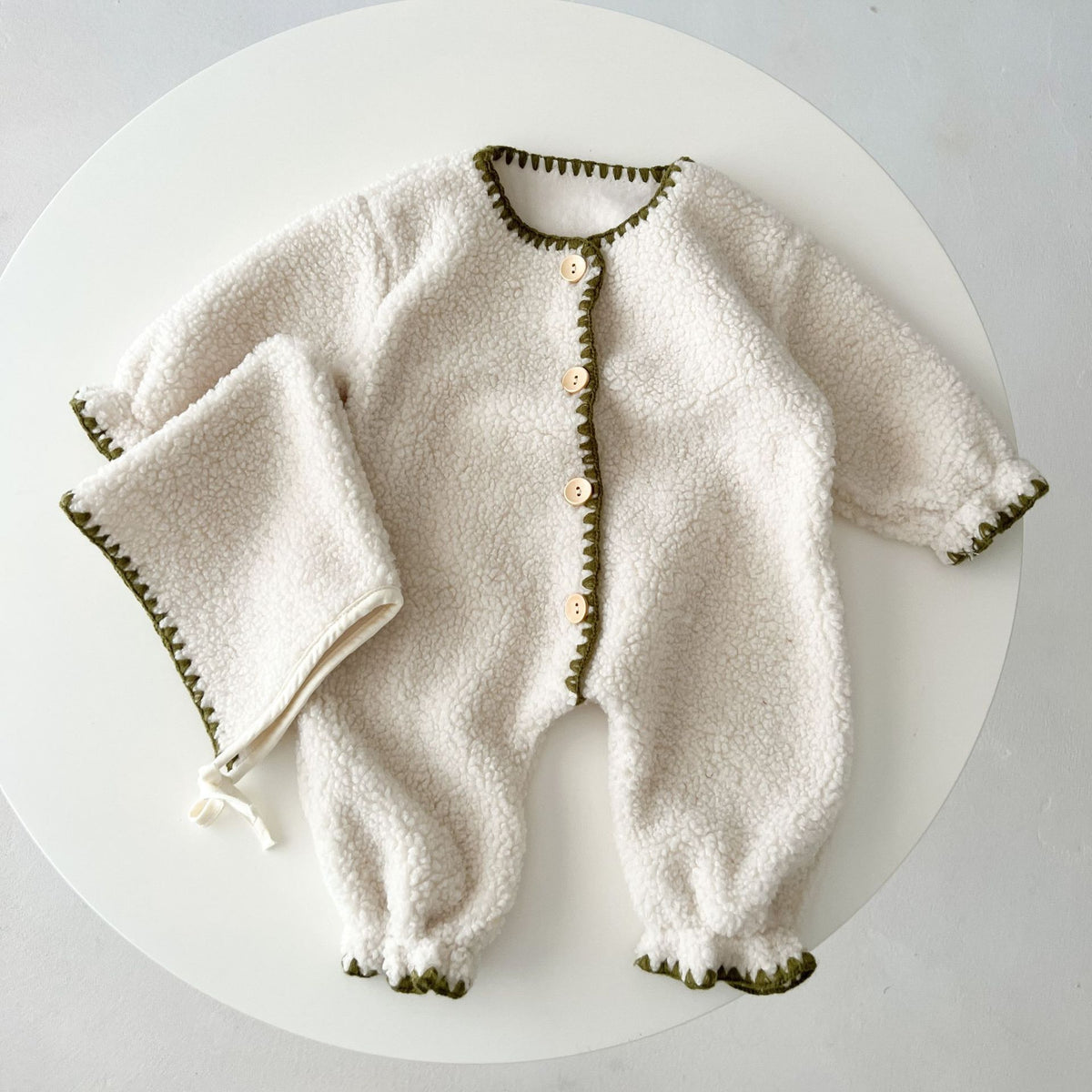 White fleece-lined baby romper with matching hat